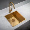 Gold kitchen sink with faucet on a white countertop