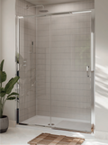A modern sliding glass shower door installed in a tiled bathroom with a white walk-in shower, a wooden bath mat, and a potted plant.